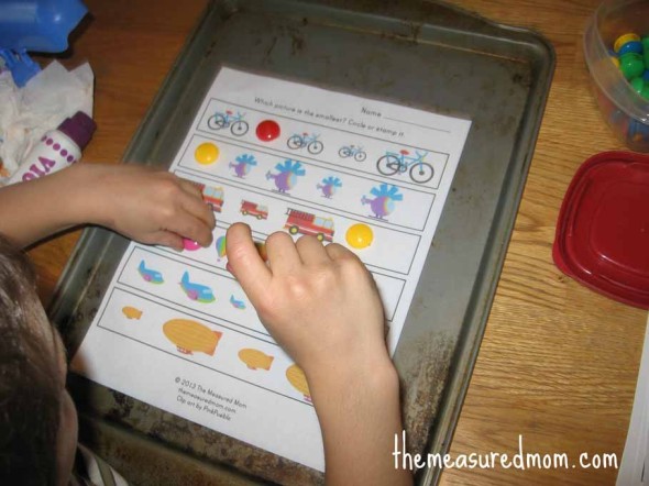 孩子把磁铁放在运输工作表上