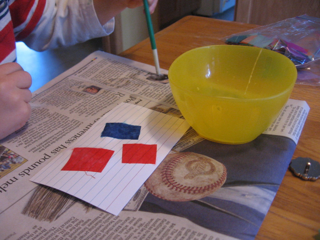 孩子在报纸和索引卡上涂胶水