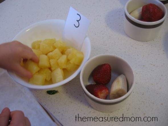 孩子从碗里取出菠萝