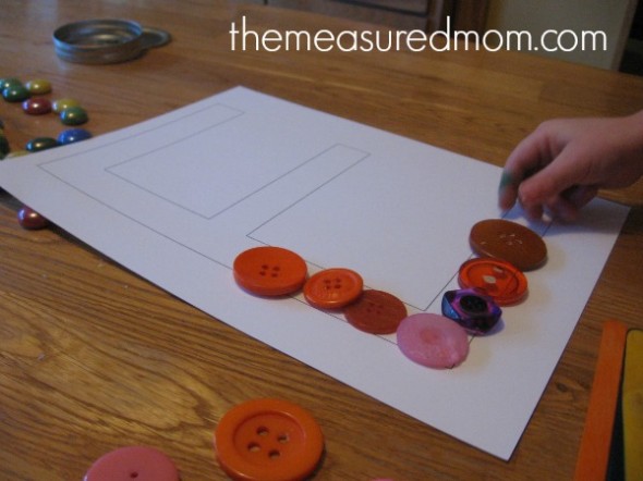 孩子把按钮放在大写字母E上