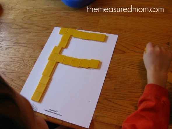 孩子把瓷砖放在大写字母F上
