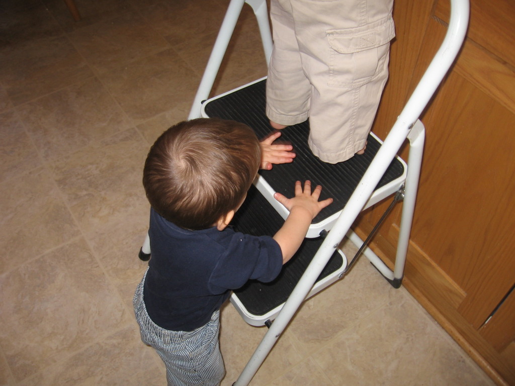 当孩子工作时，婴儿抱着凳子