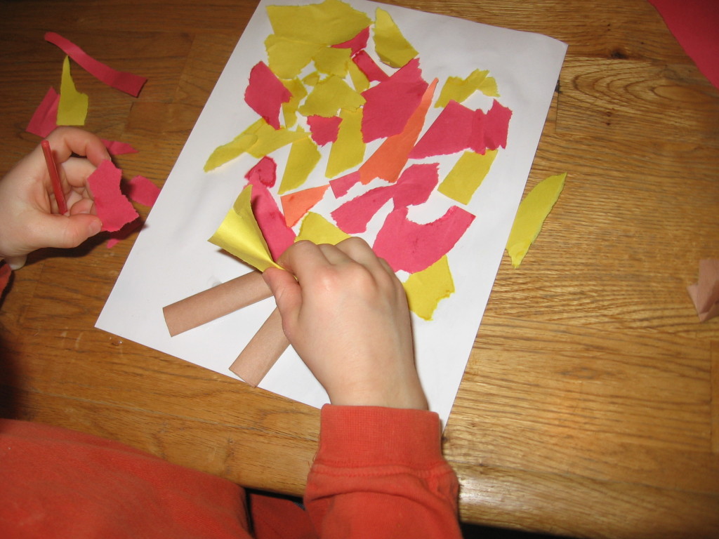 孩子把彩色纸放在纸上