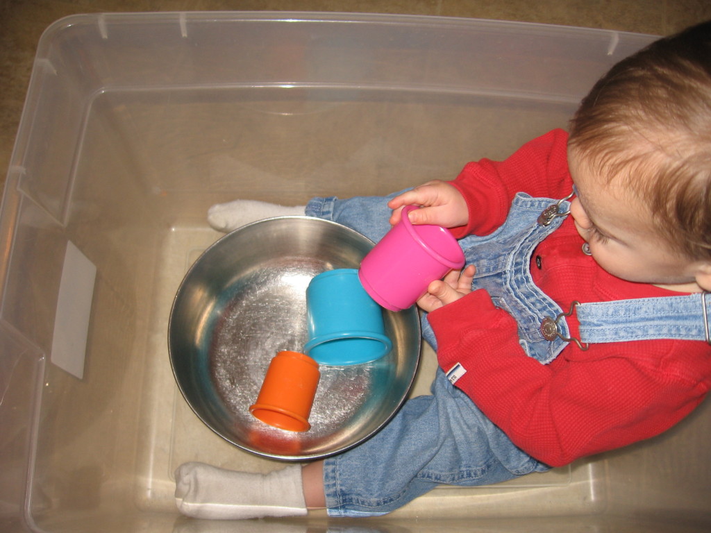 婴儿在箱子里玩杯子