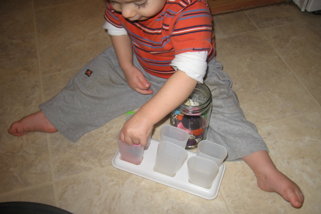 小孩将按钮放入冰棒模具中