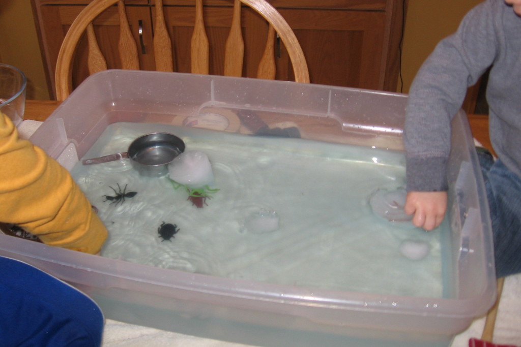 垃圾桶充满玩具昆虫，温水和冰