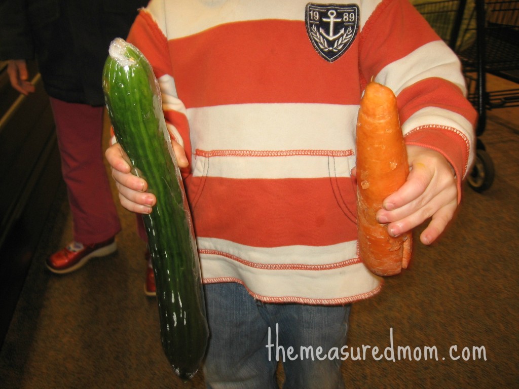 孩子拿着黄瓜和胡萝卜