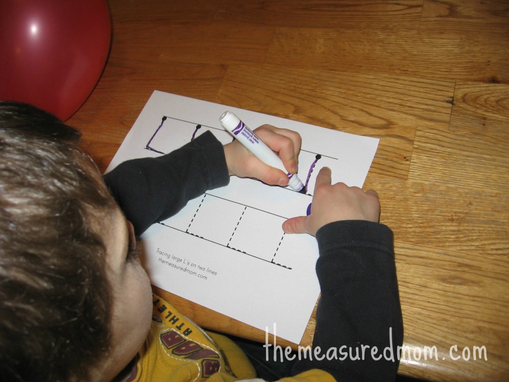 孩子在字母L的工作纸上形成L