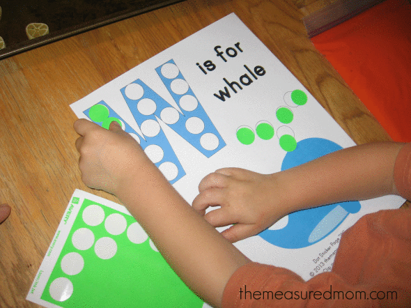 孩子在W上放置点贴纸代表鲸鱼作业纸