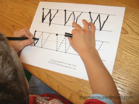 孩子在字母W的工作纸上写字