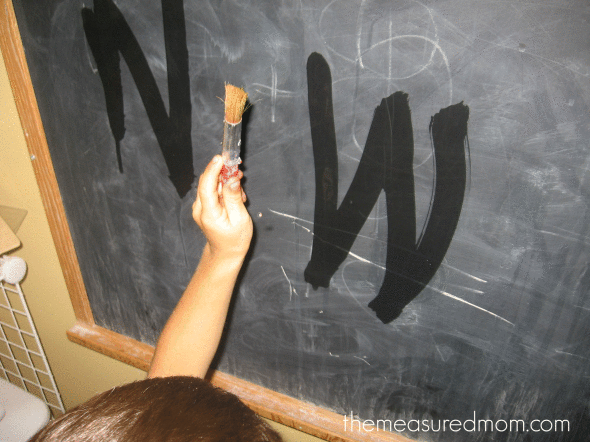 孩子用水在黑板上写字母W