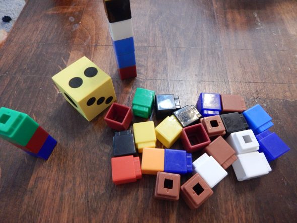 测量游戏。轮流滚动，并将许多立方体添加到塔楼。谁更大？